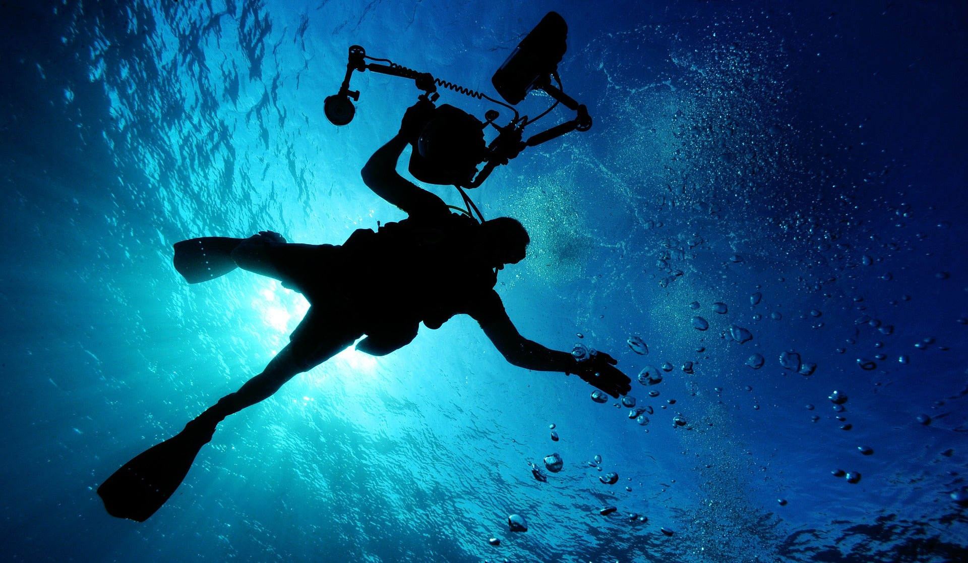 Taucher-Silhouette im Gegenlicht unter Wasser